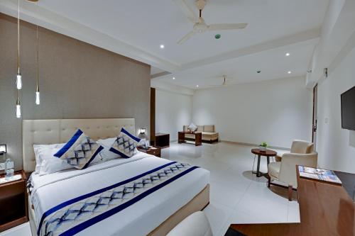 a bedroom with a large bed and a living room at Manasa Inn, Tirupati in Tirupati