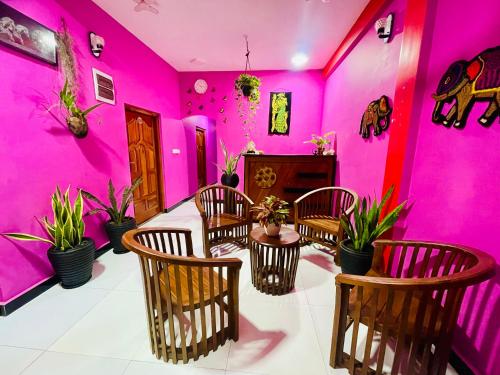 a room with pink walls and a table and chairs at Hema Holiday Villa in Trincomalee