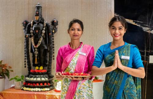two women are standing in front of a cake at Manasa Inn, Tirupati in Tirupati