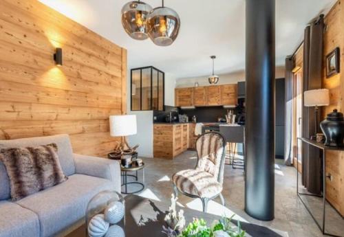 un salon avec un canapé et une cuisine dans l'établissement Appart neuf Angélus, proche navette ski, à Saint-Jean-de-Sixt