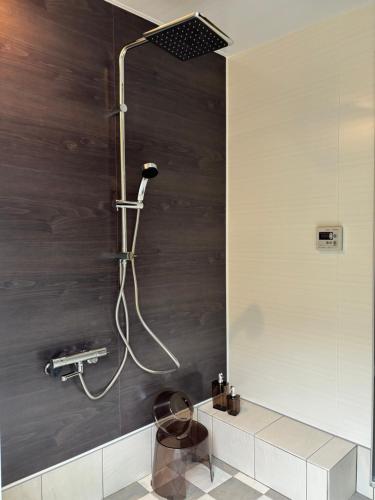 a shower in a bathroom with wooden walls at Orange open-air bath of East Villa-winter only- in Onomichi