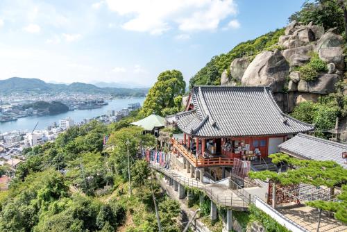 a temple on a mountain overlooking a river at Orange open-air bath of East Villa-winter only- in Onomichi