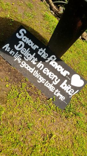 a sign sitting on the ground in the grass at Sunset Bed and Breakfast in Coffee Bay