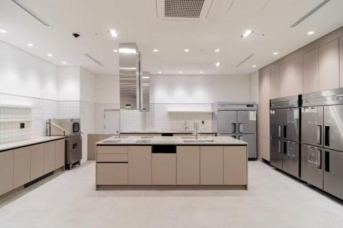 a large kitchen with white walls and stainless steel appliances at Celib Yeoui in Seoul