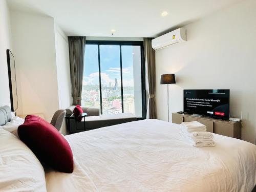 a hotel room with a large bed and a tv at Edge Central Pattaya By YoYo in Pattaya Central