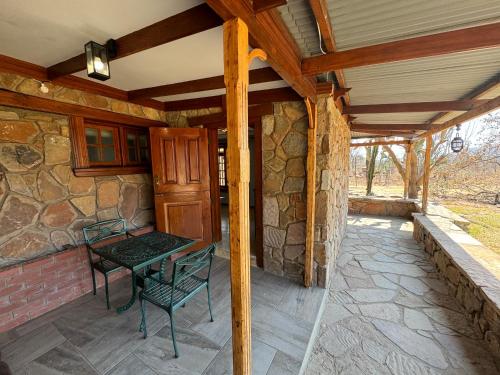 a patio with a table and chairs on a stone wall at Nectar Game Lodge in Buffelspoort