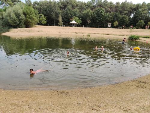a group of people swimming in a lake at Tipi Cheyenne des monteaux in Vivy