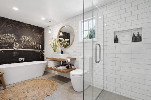 a bathroom with a tub and a toilet and a sink at The Venus room at Glendower Homestead in Greytown
