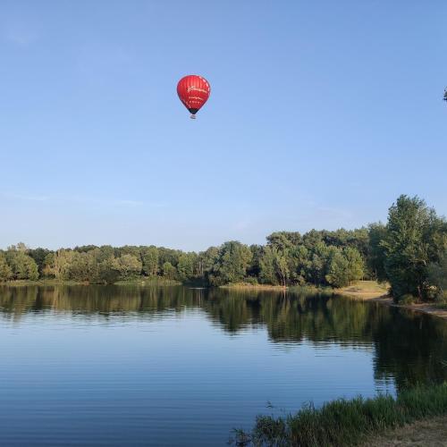a hot air balloon flying over a lake at Tipi Cheyenne des monteaux in Vivy