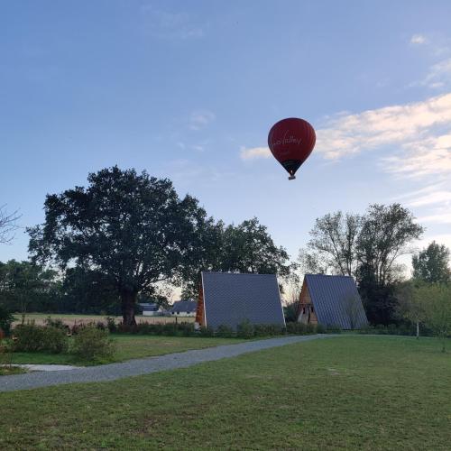 a hot air balloon in the sky over a field at Tipi Cheyenne des monteaux in Vivy