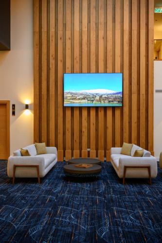a living room with two couches and a flat screen tv at Oaks Hotel  in Golan Heights