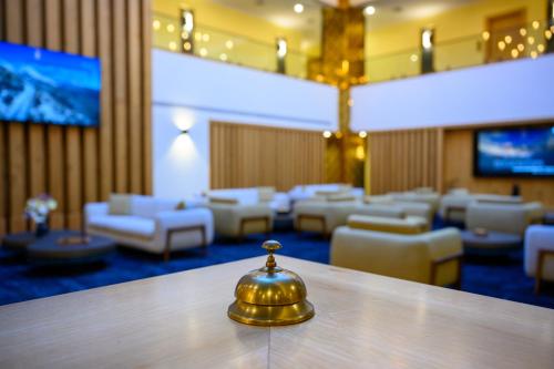 a waiting room with a gold bell on a table at Oaks Hotel  in Golan Heights