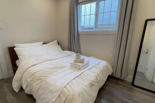 a bedroom with a white bed with a towel on it at Modern Spacious 1BR minutes away from Main St in Vancouver