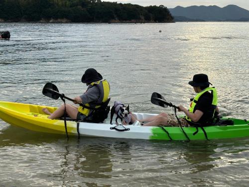 two people and a dog in a kayak on the water at Orange open-air bath of East Villa-winter only- in Onomichi