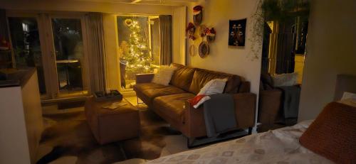 a living room with a couch and a christmas tree at Verborgen Parel aan de Rotte in Rotterdam
