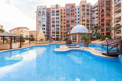 a large swimming pool in a resort with tall buildings at VERDEMAR 3, PLAYA HONDA in Cabo de Palos