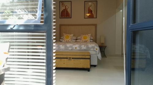 a bedroom with a bed with flowers on it at 81 A & Away Studio apartment West Wing in Mossel Bay