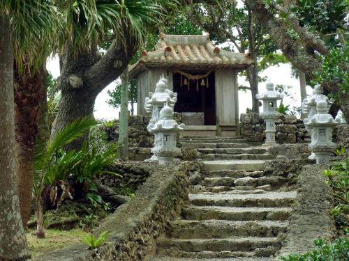 a small shrine in a garden with stairs at MAETAKAYA しまんちゅ in Ishigaki Island