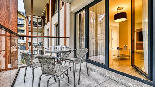 a patio with a table and chairs on a balcony at Źródło Izery przy gondoli VIP Sauna, Siłownia, Bawialnia by Royal Aparts in Świeradów-Zdrój