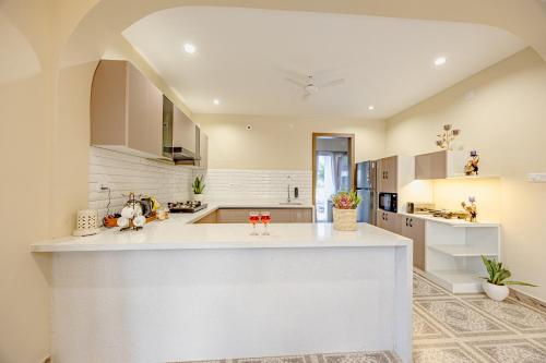 a large white kitchen with a large white counter top at ELIVAAS Heaven in Hills Mountara 3 BHK Villa with Lounge & Pvt Pool in Udaipur