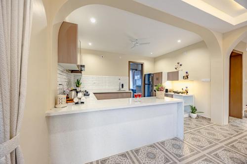 a kitchen with a large white island in a room at ELIVAAS Heaven in Hills Mountara 3 BHK Villa with Lounge & Pvt Pool in Udaipur