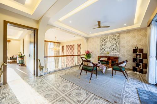 a living room with a dining room table and chairs at ELIVAAS Heaven in Hills Mountara 3 BHK Villa with Lounge & Pvt Pool in Udaipur