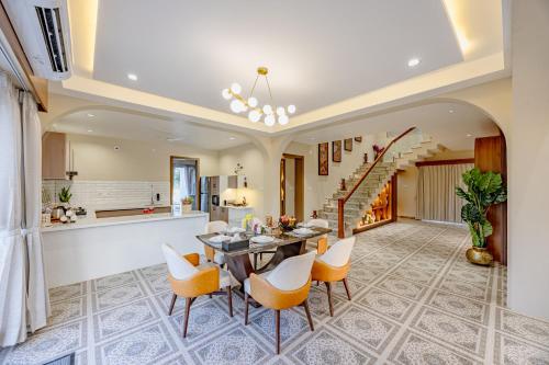 an open kitchen and dining room with a table and chairs at ELIVAAS Heaven in Hills Mountara 3 BHK Villa with Lounge & Pvt Pool in Udaipur