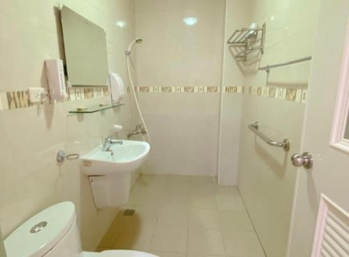 a white bathroom with a toilet and a sink at Village Villa B&B in Zhuqi