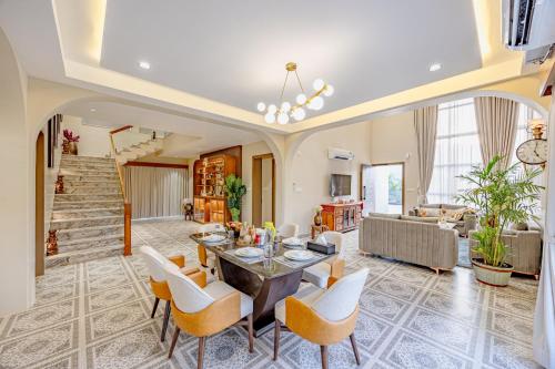a living room with a table and chairs at ELIVAAS Heaven in Hills Mountara 3 BHK Villa with Lounge & Pvt Pool in Udaipur