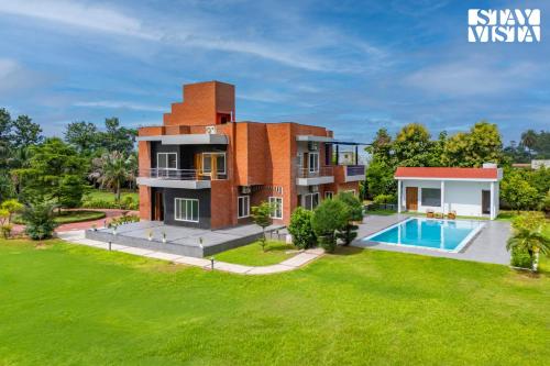 an image of a house with a swimming pool at StayVista at Imperial Isle 4BHK with FREE BF Luxury Pool Villa in Sohna Delhi in Sohna