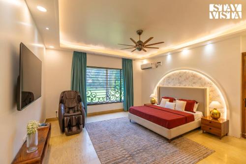 a bedroom with a bed and a large window at StayVista at Imperial Isle 4BHK with FREE BF Luxury Pool Villa in Sohna Delhi in Sohna