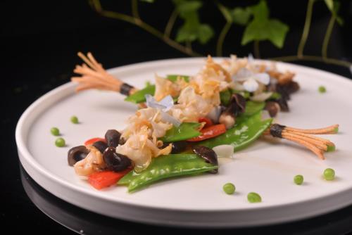 a plate of food with vegetables on a table at Ocean Hotel Guangzhou - Free Shuttle Bus to Canton Fair, Tao Jin railway station in Guangzhou
