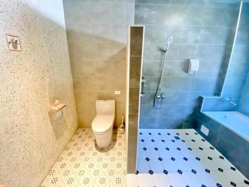 a bathroom with a toilet and a sink and a tub at Village Villa B&B in Zhuqi