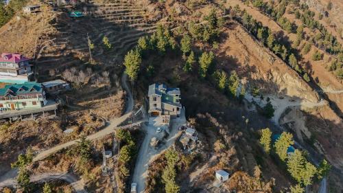 an aerial view of a house on a mountain at SaffronStays Alpine blue-6 bhk villa with private deck and valley views from each room in Shimla