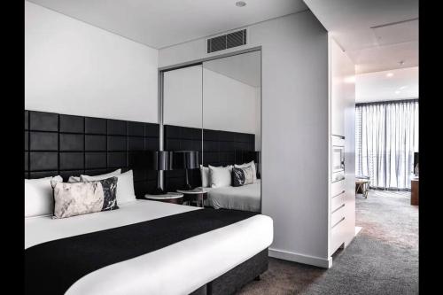 a hotel room with a bed and a mirror at Comfortable&Convenient Rental Apartment in Chatswood in Sydney