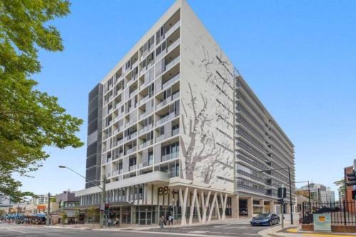 a large white building on a city street at Comfortable&Convenient Rental Apartment in Chatswood in Sydney
