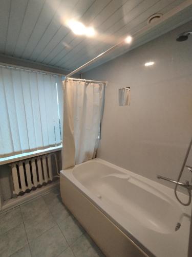 a bathroom with a bath tub with a shower curtain at Sweet home in Tauragė
