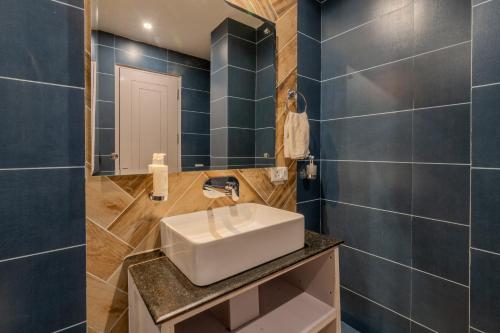 a bathroom with a sink and a mirror at SaffronStays Alpine blue-6 bhk villa with private deck and valley views from each room in Shimla