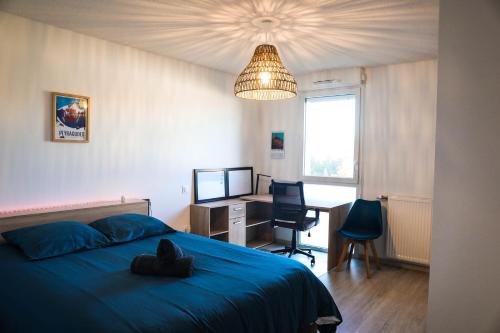 a bedroom with a blue bed and a desk and a lamp at Havre de paix près de Toulouse Parking inclus in Quint-Fonsegrives
