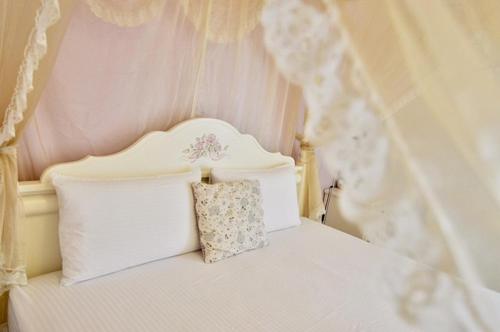 a white bed with a pillow on top of it at Village Villa B&B in Zhuqi