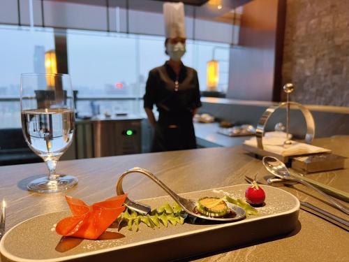 a plate of food on a table with a glass of wine at Ocean Hotel Guangzhou - Free Shuttle Bus to Canton Fair, Tao Jin railway station in Guangzhou