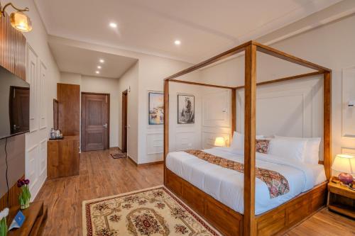 a bedroom with a canopy bed in a room at SaffronStays Alpine blue-6 bhk villa with private deck and valley views from each room in Shimla