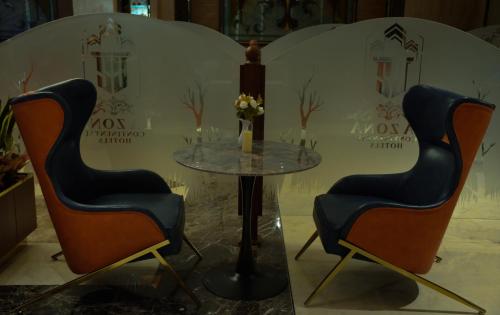 two chairs and a table in front of a wall at La Zona Continental Hotel in Dubai