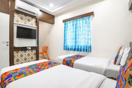 a hotel room with two beds and a tv at FabExpress Geet Residency in Mumbai