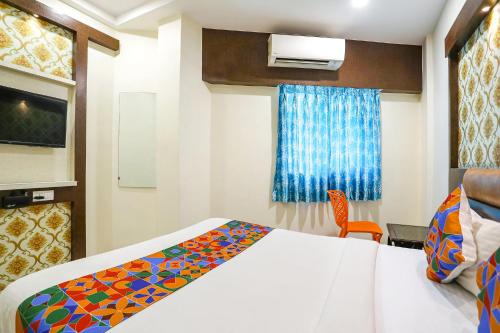 a hotel room with a bed and a chair at FabExpress Geet Residency in Mumbai