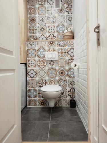 une salle de bain avec toilettes et un mur carrelé dans l'établissement chambre à louer, à Lyon