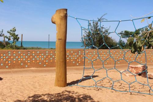 a fence in the sand next to a beach at Guwarri Bayside Retreat in Broome