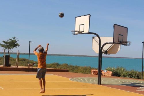 a man playing basketball on a basketball hoop at Guwarri Bayside Retreat in Broome