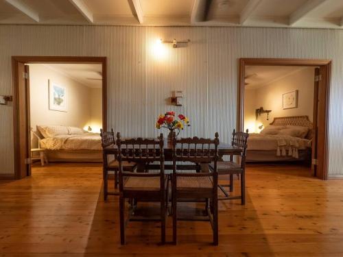 a dining room with a table and chairs and a bedroom at Guwarri Bayside Retreat in Broome