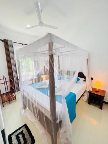 une chambre avec un lit à baldaquin dans l'établissement JO Residence - Tangalle, à Tangalle